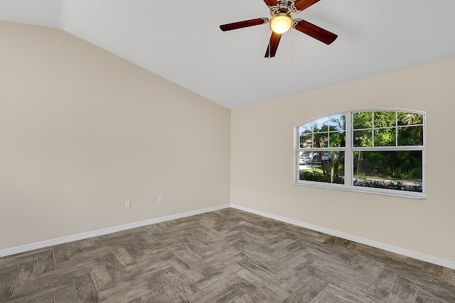 empty room with dark parquet floors, ceiling fan, and vaulted ceiling