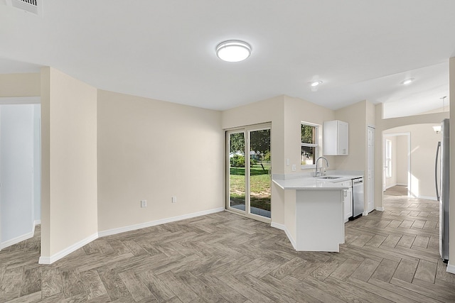 kitchen with light parquet flooring, white cabinetry, sink, and stainless steel appliances