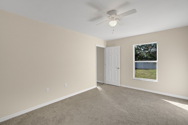 spare room with ceiling fan and carpet