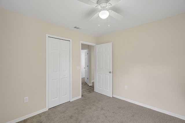 unfurnished bedroom featuring ceiling fan, a closet, and light colored carpet