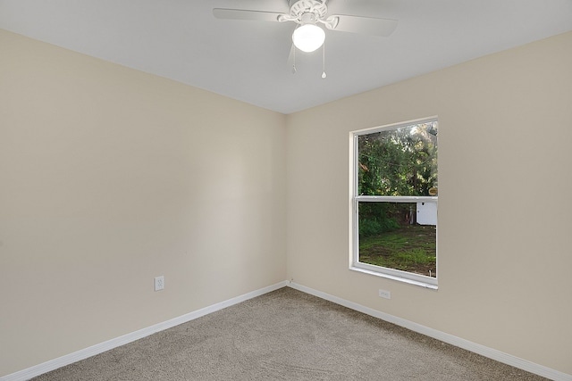 spare room with light colored carpet and ceiling fan