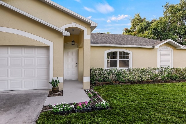 entrance to property featuring a garage and a yard