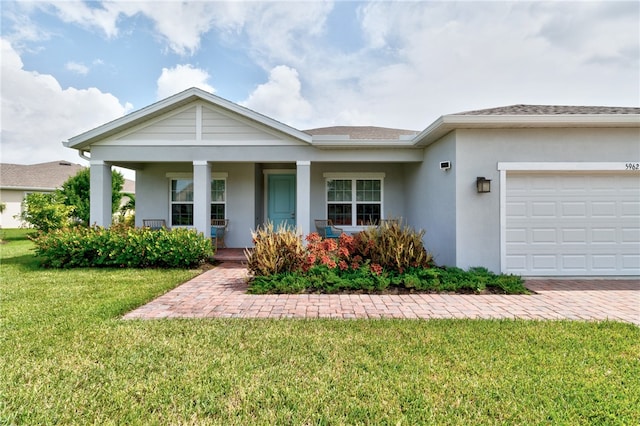 view of front of home featuring a porch, a garage, and a front lawn