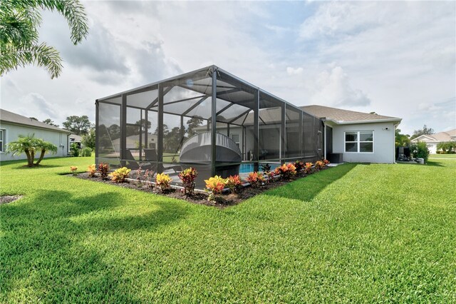 rear view of property with a lanai and a yard