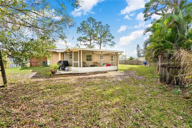 back of property featuring a sunroom and a yard