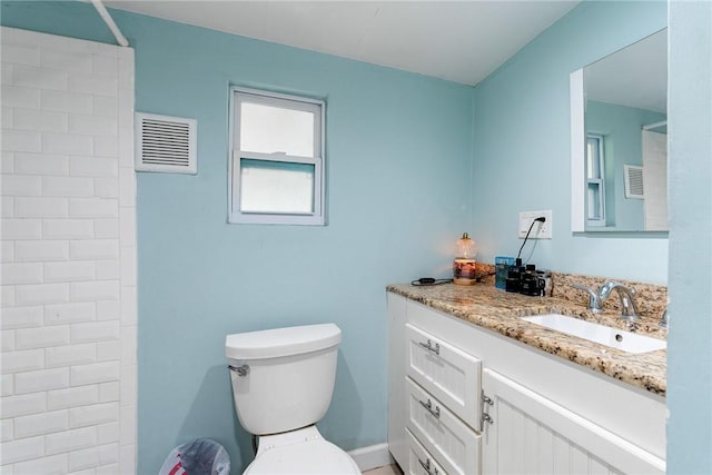 bathroom featuring vanity, a shower, and toilet