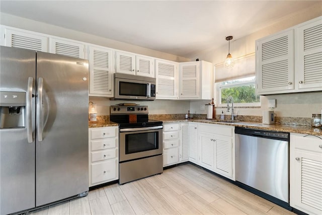 kitchen with pendant lighting, sink, white cabinetry, and stainless steel appliances