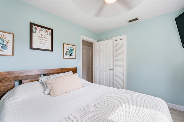 bedroom featuring hardwood / wood-style flooring, ceiling fan, and a closet