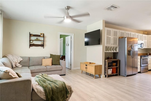 living room featuring light hardwood / wood-style flooring and ceiling fan