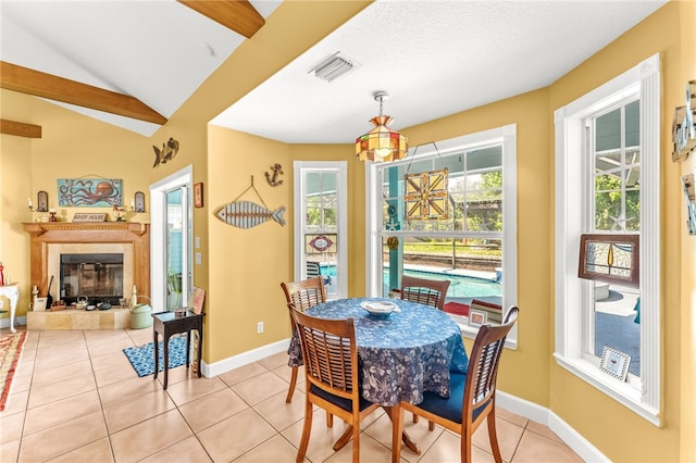 tiled dining area with lofted ceiling, a fireplace, and plenty of natural light