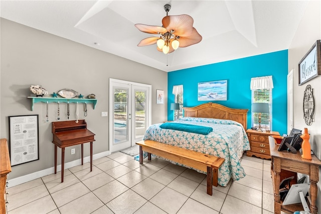 bedroom with access to exterior, light tile patterned floors, a raised ceiling, and french doors