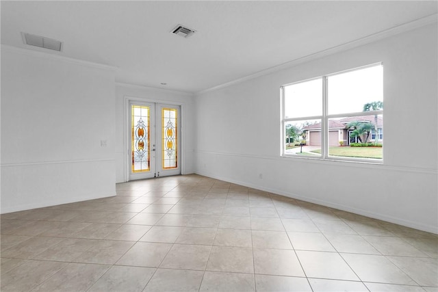 unfurnished room with light tile patterned floors, ornamental molding, and french doors