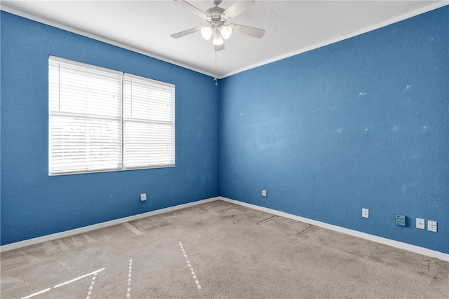 carpeted empty room with ceiling fan and ornamental molding