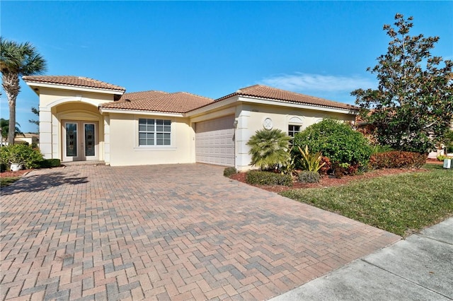 mediterranean / spanish-style home with a garage and french doors