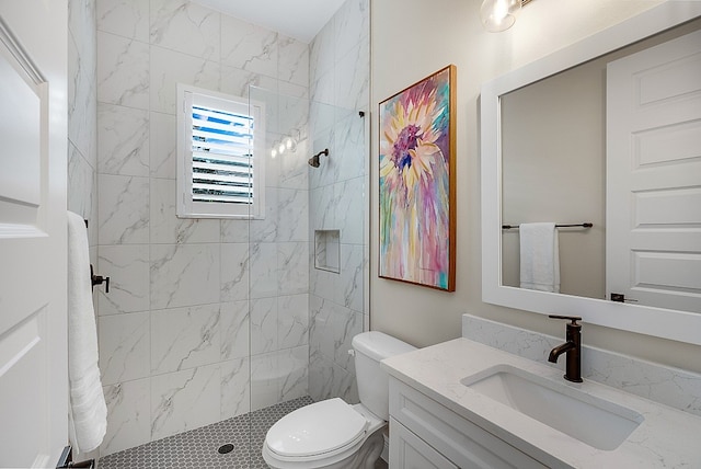 bathroom featuring vanity, toilet, and tiled shower