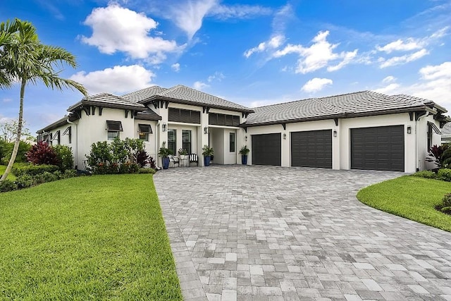 prairie-style home featuring a garage and a front lawn