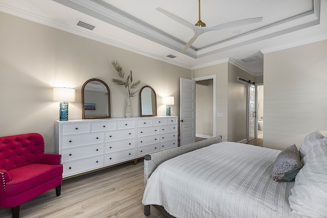 bedroom with a raised ceiling, ceiling fan, crown molding, and light wood-type flooring