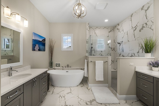 bathroom with vanity, independent shower and bath, and an inviting chandelier