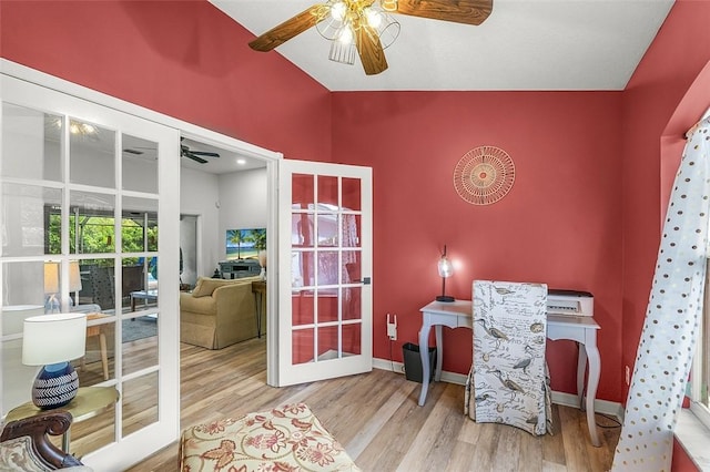 interior space with baseboards, ceiling fan, vaulted ceiling, and wood finished floors