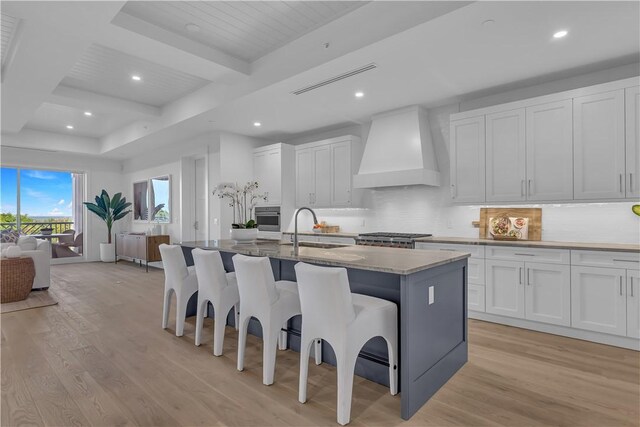 950 Surfsedge Way Unit 205, Vero Beach, FL 32963 - kitchen featuring custom exhaust hood, a sink, light wood-style floors, backsplash, and recessed lighting