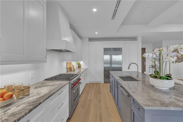 950 Surfsedge Way Unit 205, Vero Beach, FL 32963 - kitchen with a sink, high end appliances, premium range hood, white cabinets, and recessed lighting