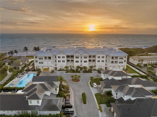 aerial view at dusk featuring a water view