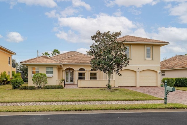 mediterranean / spanish-style house featuring a garage and a front lawn