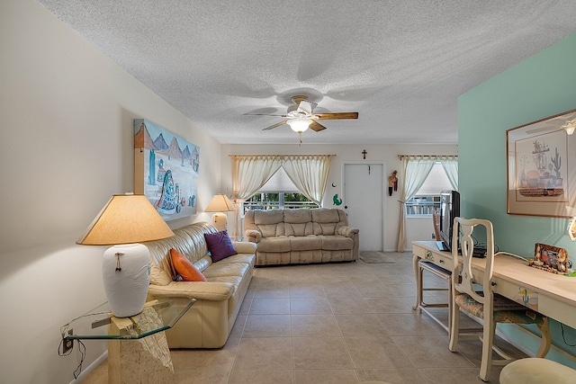 living room with a textured ceiling, ceiling fan, and light tile patterned flooring