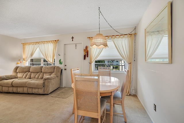 dining room featuring a chandelier, a textured ceiling, and tile patterned floors