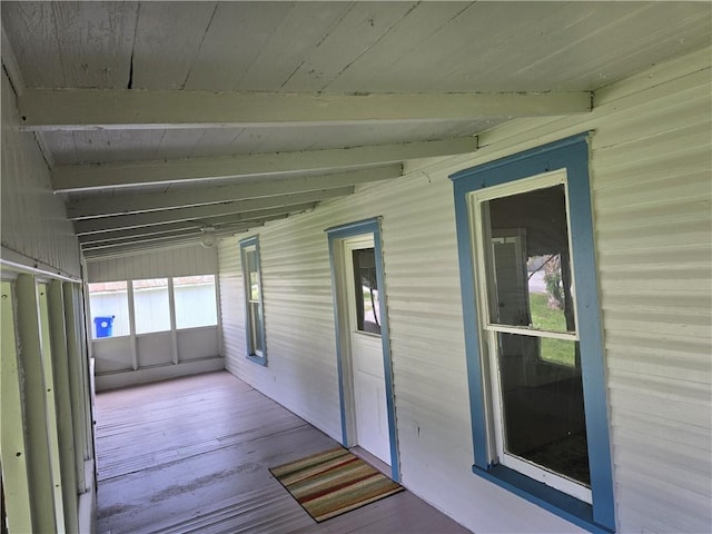 unfurnished sunroom with beamed ceiling