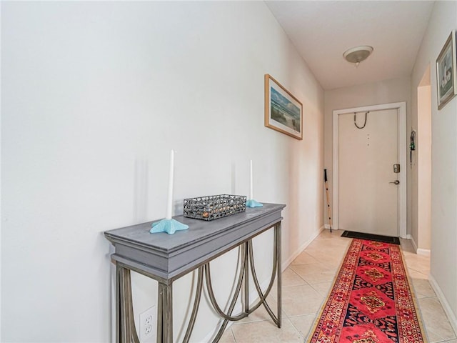 doorway to outside featuring baseboards and light tile patterned floors