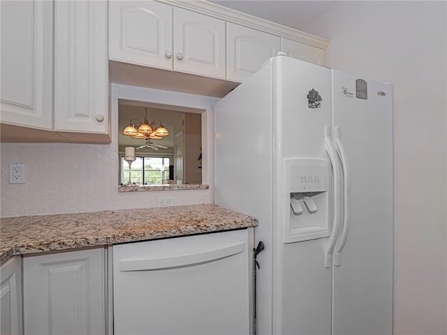 kitchen featuring tasteful backsplash, light stone counters, white fridge with ice dispenser, white cabinetry, and a notable chandelier