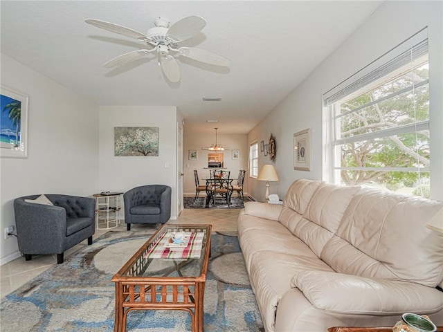 living area with ceiling fan, visible vents, baseboards, and light tile patterned flooring