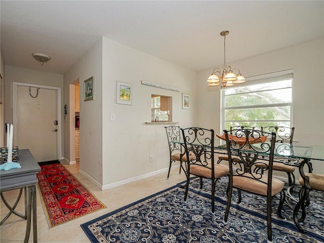 dining area with an inviting chandelier, baseboards, and light tile patterned flooring