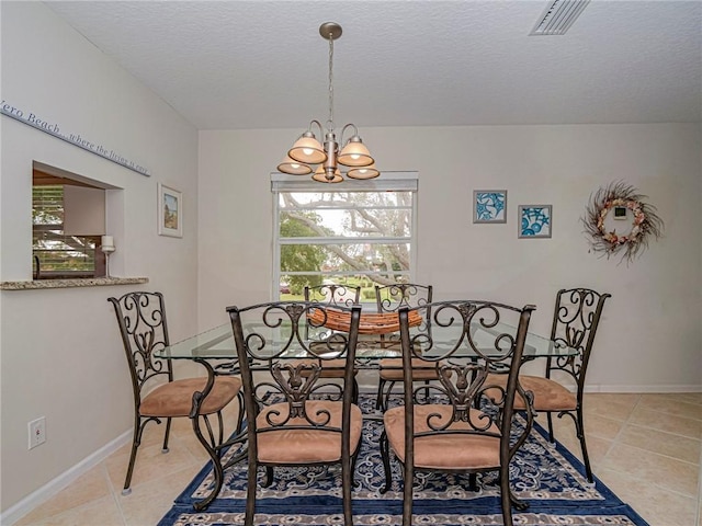 dining area with a notable chandelier, light tile patterned floors, visible vents, a textured ceiling, and baseboards