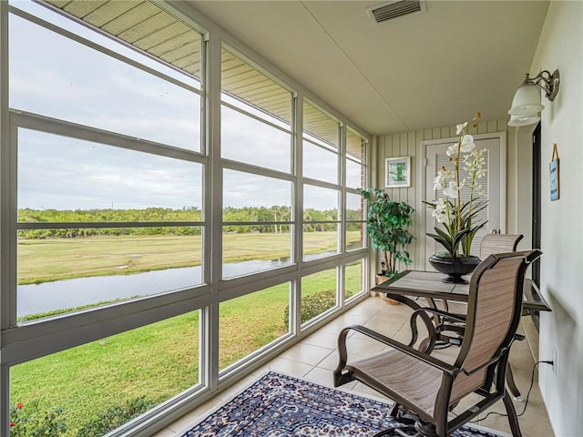 sunroom / solarium with a water view