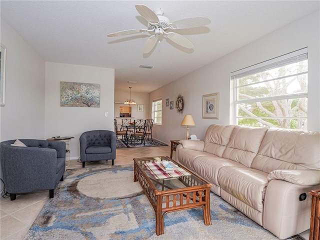 living area with visible vents, ceiling fan, and light tile patterned flooring