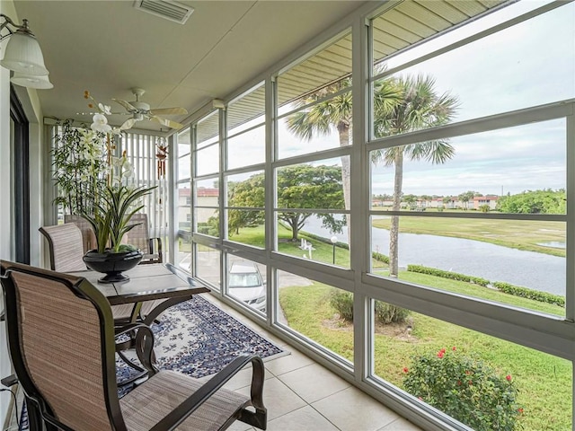 sunroom / solarium with visible vents, a water view, and ceiling fan