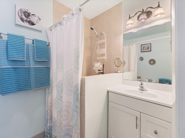 bathroom featuring walk in shower and vanity