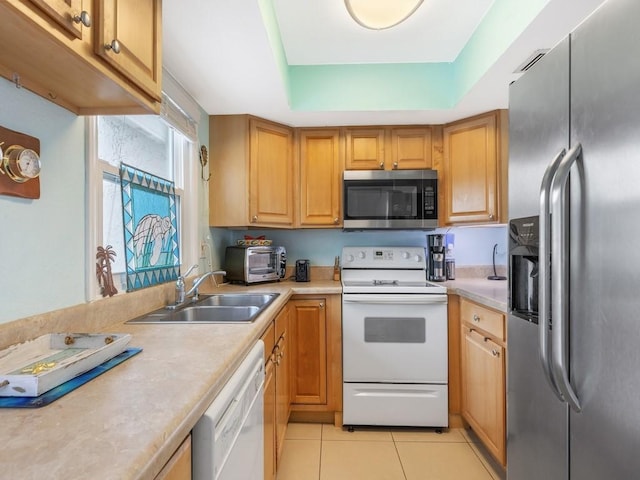 kitchen featuring a raised ceiling, appliances with stainless steel finishes, sink, and light tile patterned flooring