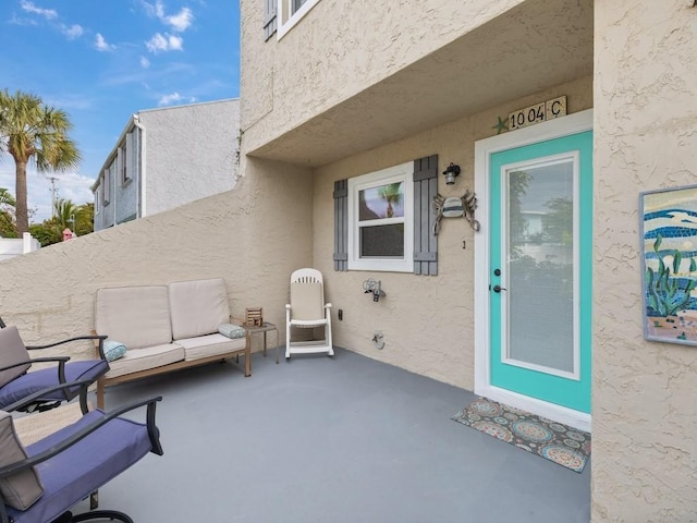 view of exterior entry with a patio area