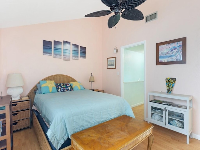 bedroom with ceiling fan, hardwood / wood-style flooring, and vaulted ceiling