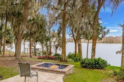 exterior space featuring a water view and a fire pit