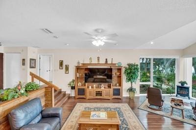 living room featuring dark wood-type flooring and ceiling fan