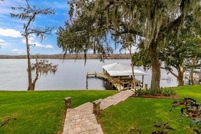 dock area with a lawn and a water view