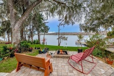 view of patio with a water view and a fire pit