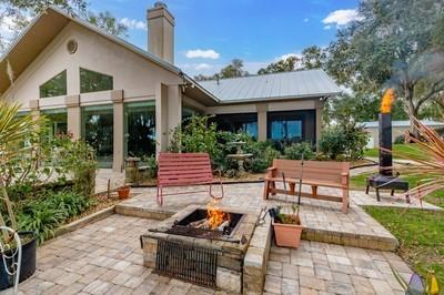 back of property with a fire pit and a patio