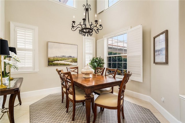 tiled dining area with a high ceiling and a notable chandelier