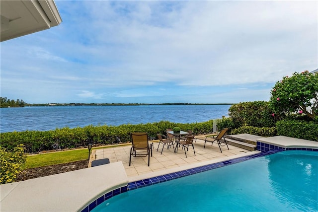 view of pool with a patio area and a water view