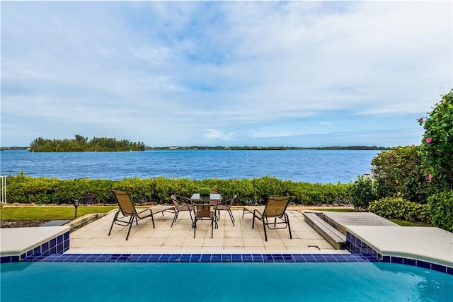 view of pool featuring a patio area and a water view